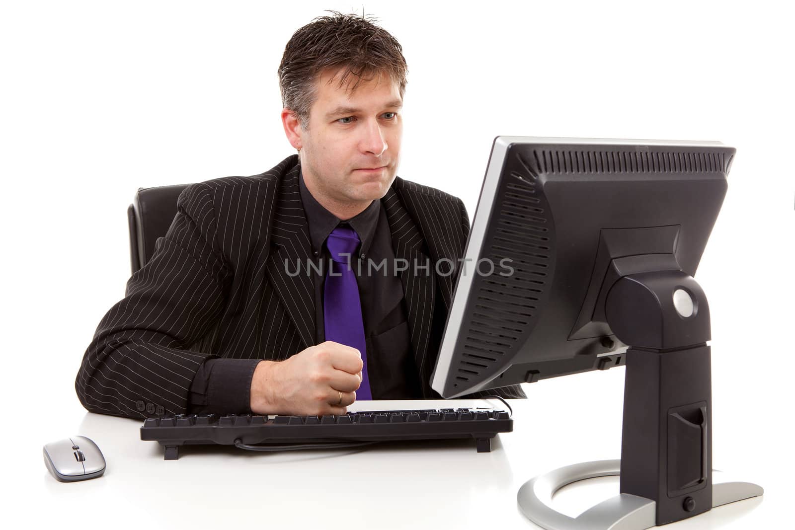 Businessman sitting behind desk is angry, strike his fist on the keyboard, over white background