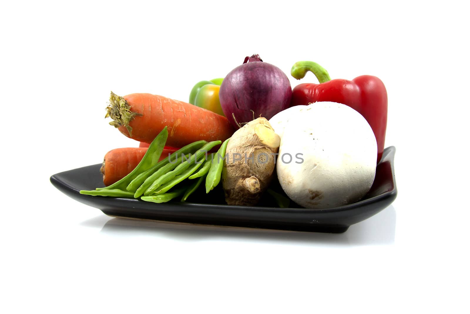Black plate with different vegetables isolated on white background