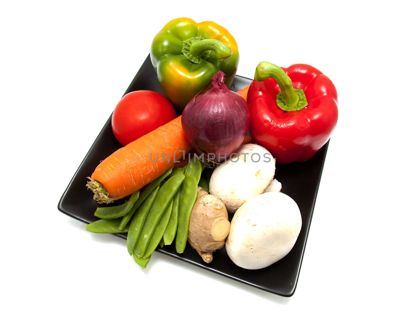 Black plate with different vegetables isolated on white background