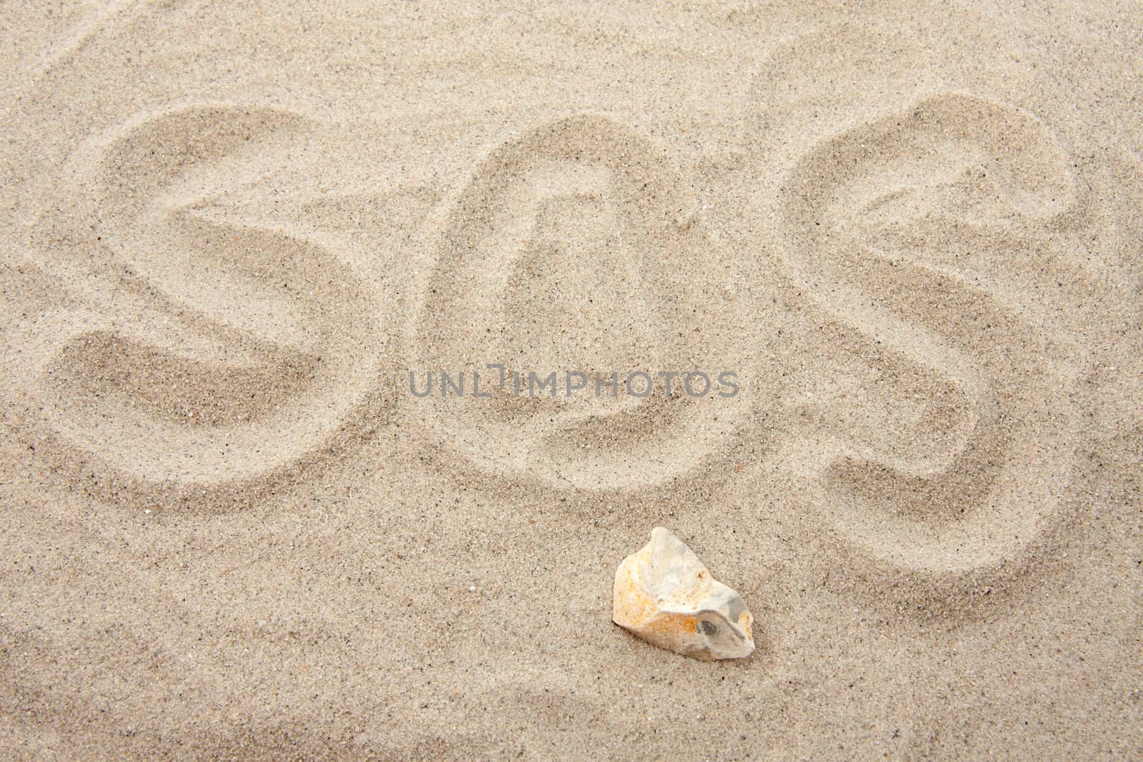 SOS letters written in sand in closeup