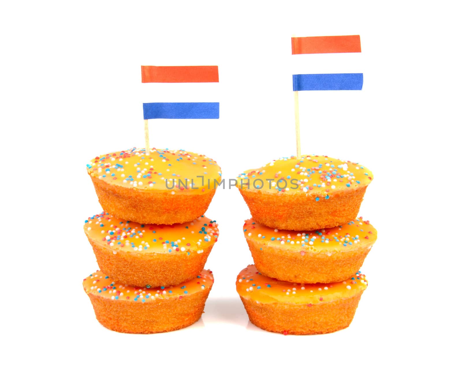 pile of orange cake cookies for Dutch soccer with confetti and flags over white background