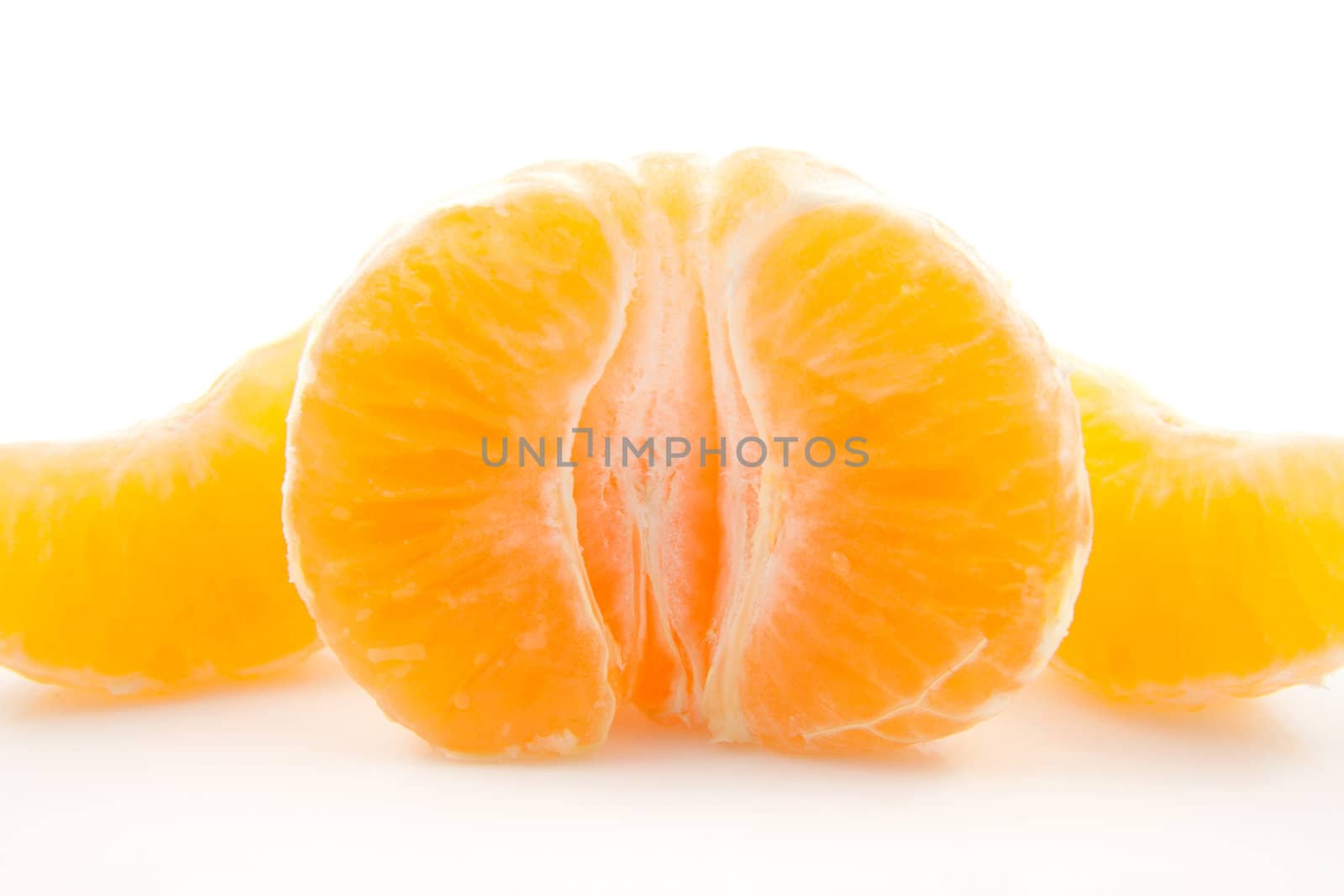 peeled mandarin in closeup over white background
