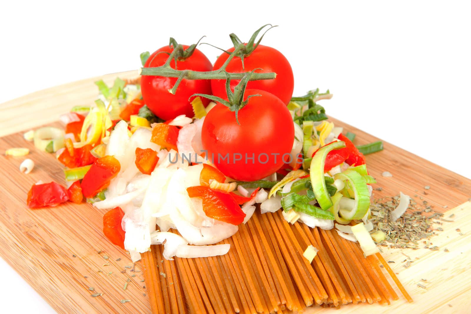Ingredients for spaghetti on wooden cutting board over white background