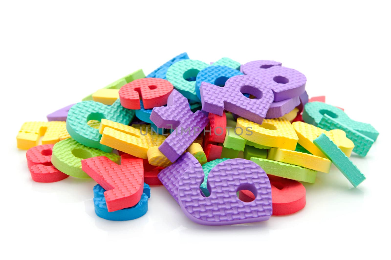 Stack of colorful foam letters over white background