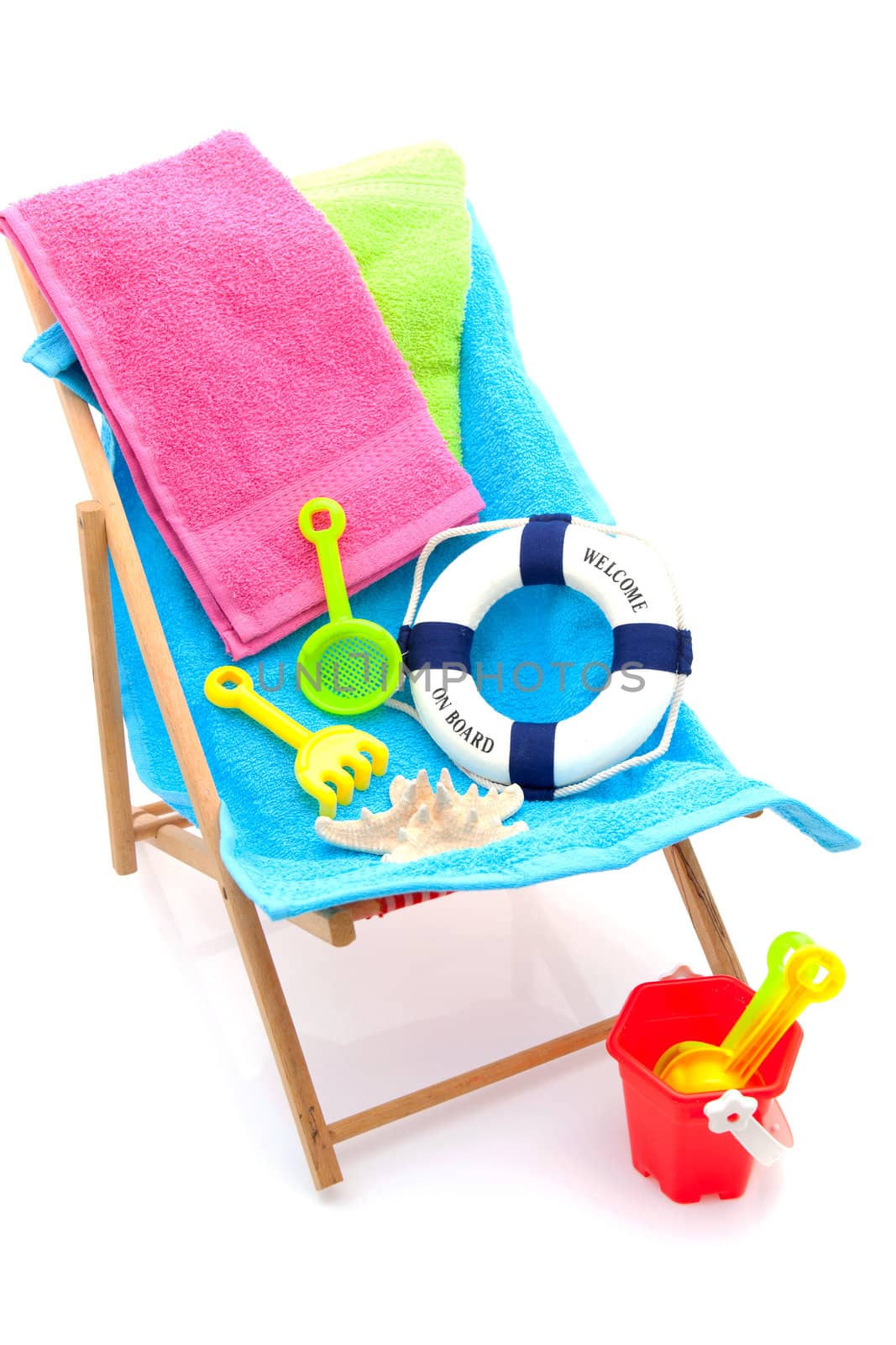beach chair with colorful towels and toys over white background