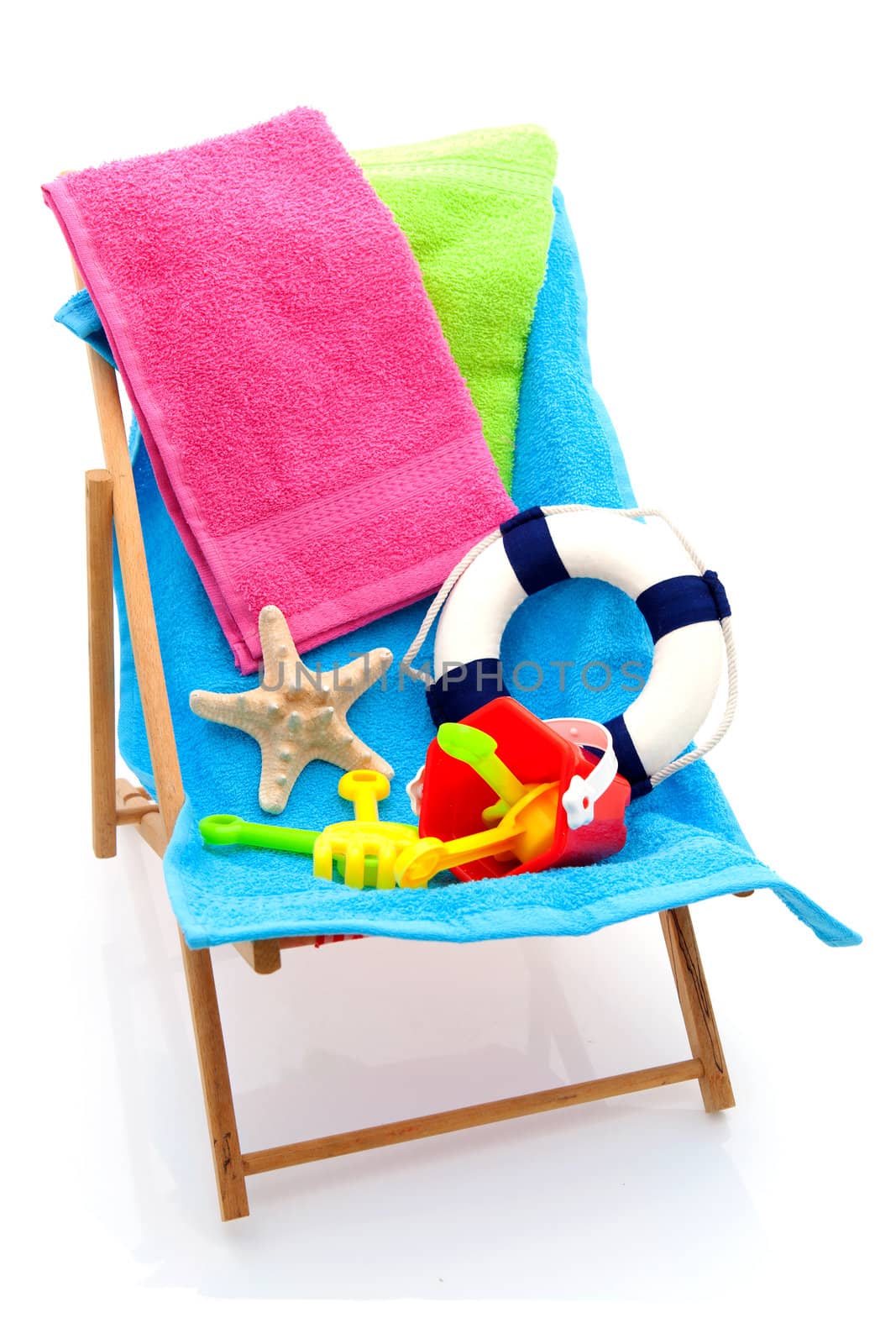 beach chair with colorful towels and toys over white background