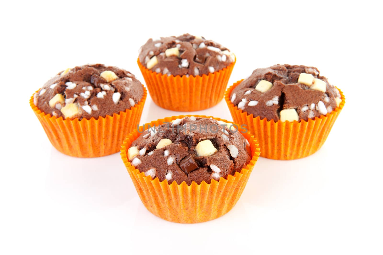 four brown home baked cupcake with chocolate pieces isolated on white background