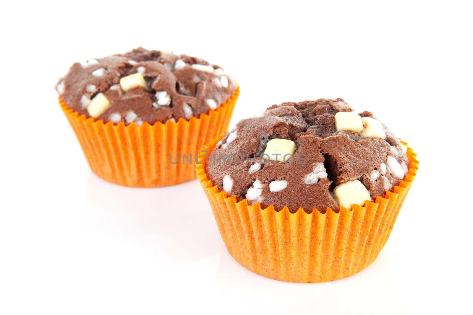 two brown home baked cupcake with chocolate pieces isolated on white background