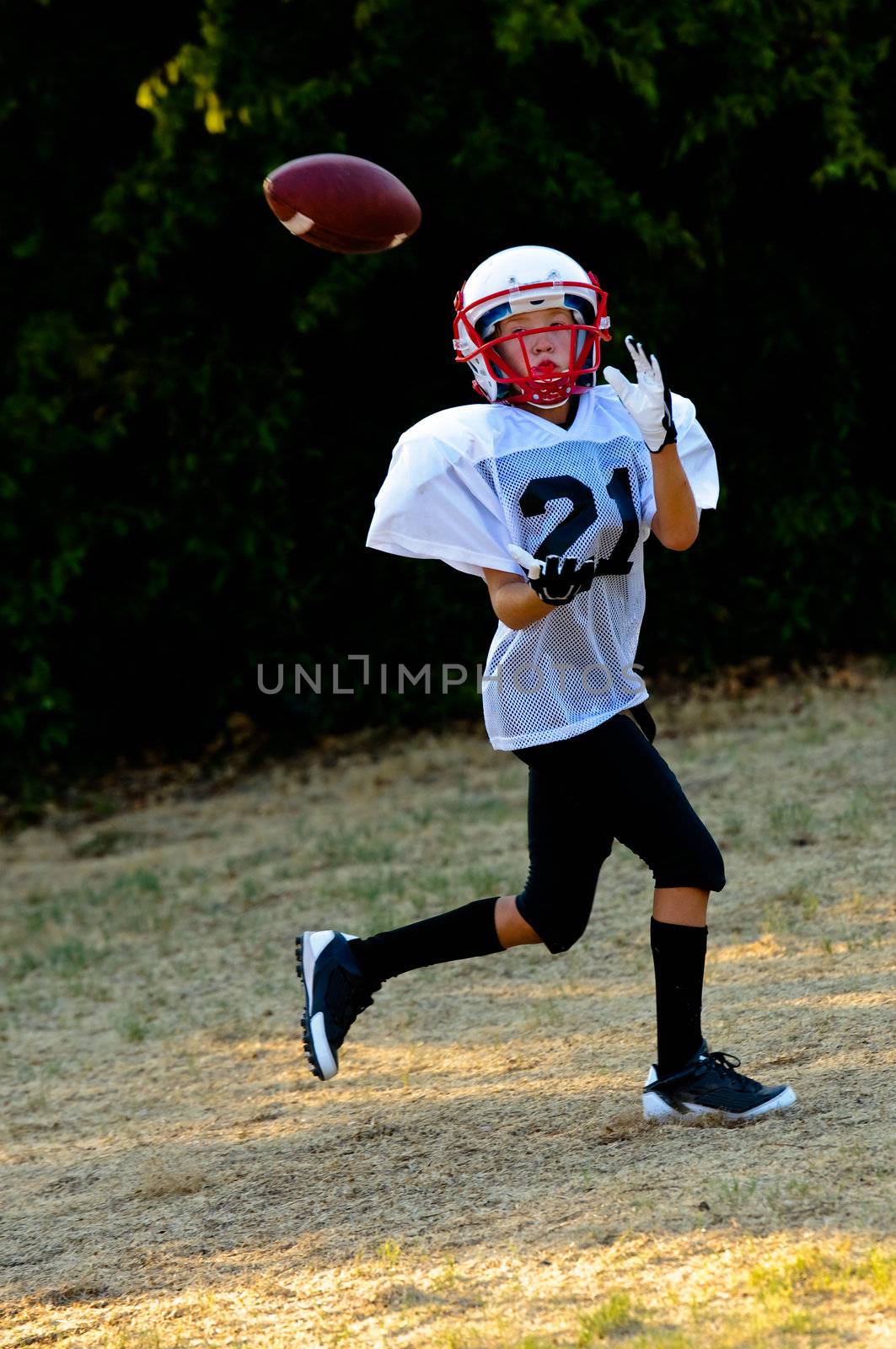 Young football player about to catch the football.