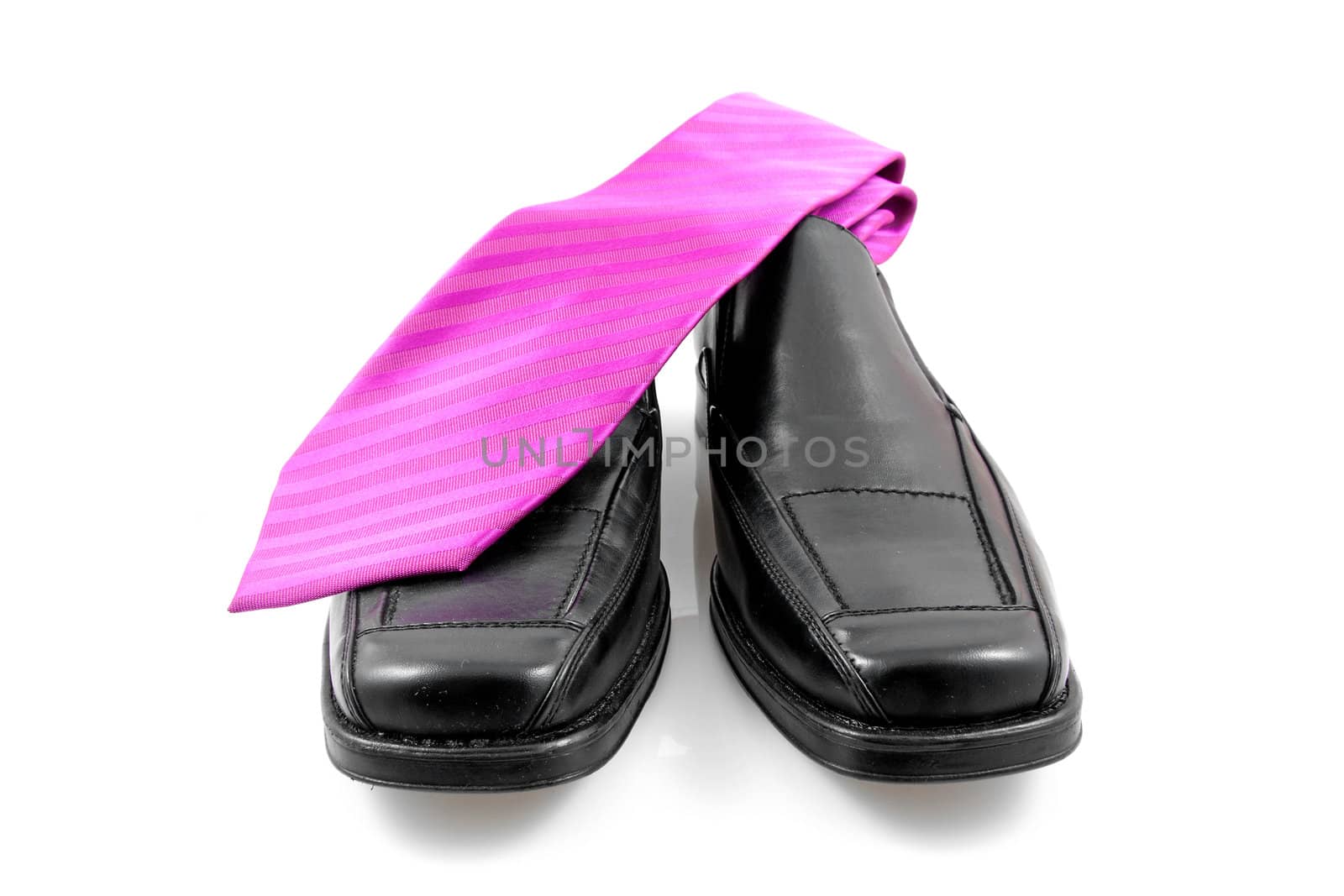 Pair of black male business shoes and pink tie isolated on white background