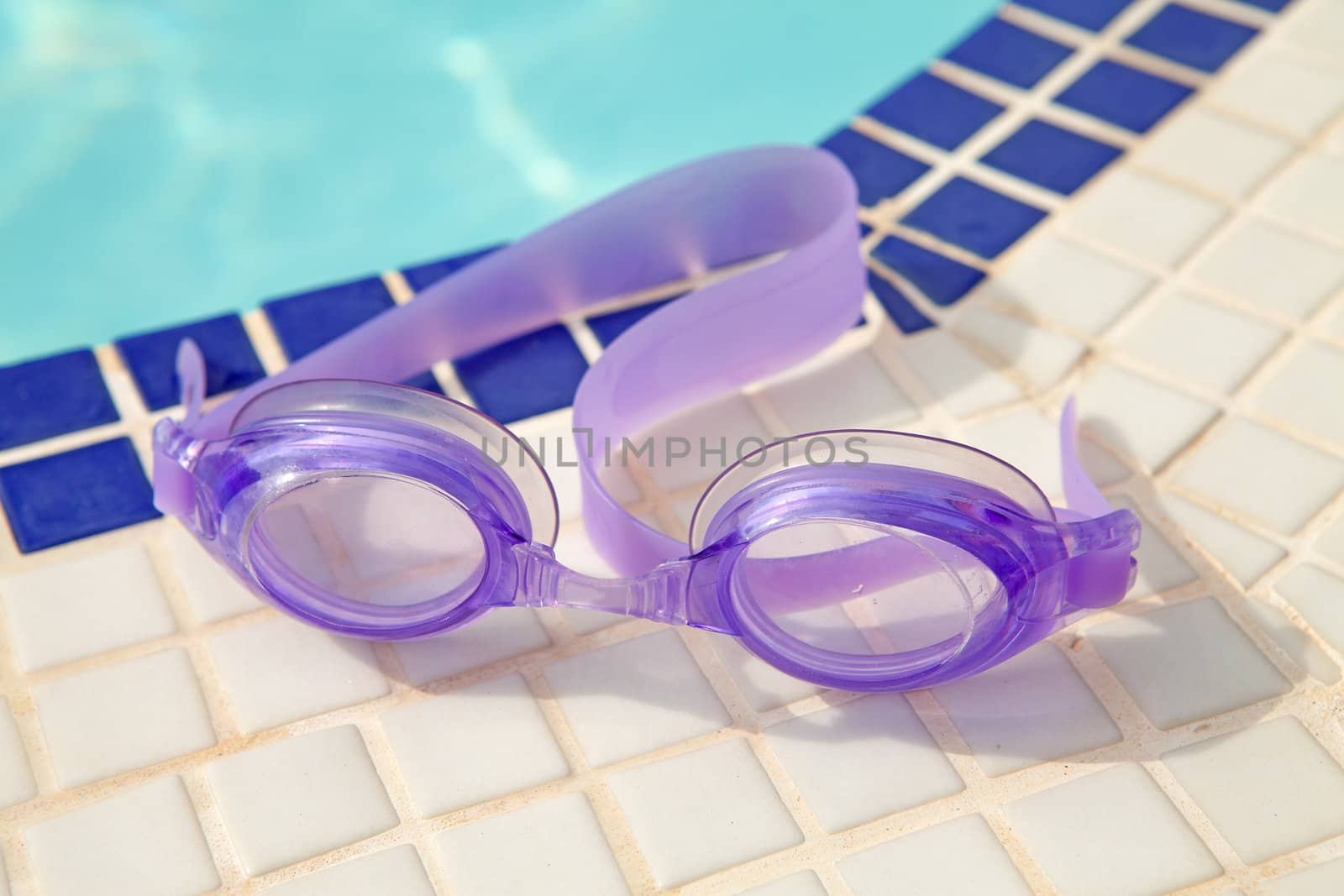 purple diving goggles near the swim pool on sunny day