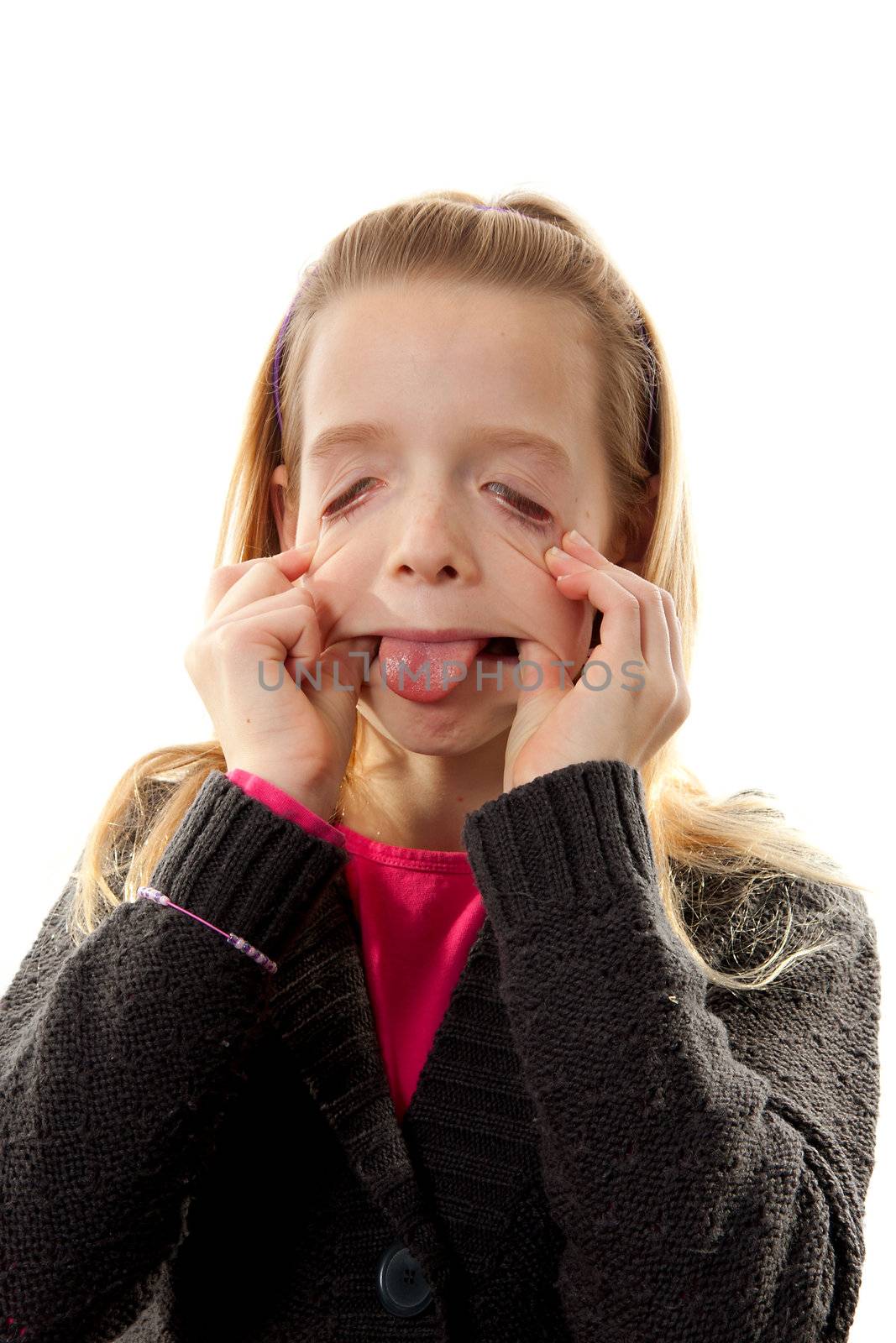 Girl is making funny face, she sticks her tongue out and pulling eyes over white background