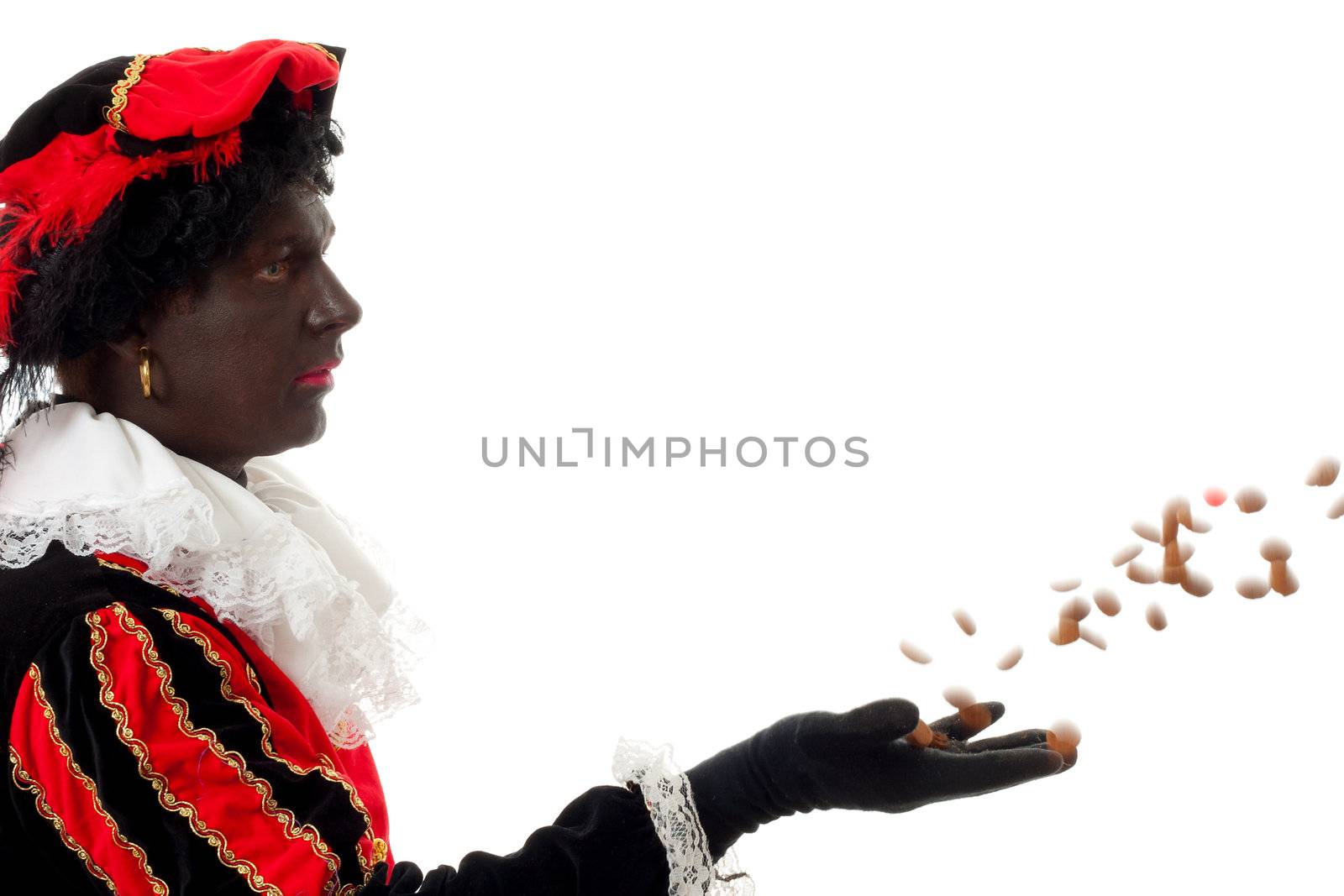 Zwarte piet ( black pete) typical Dutch character part of a traditional event celebrating the birthday of Sinterklaas in december over white background throwing pepernoten ( ginger nuts)