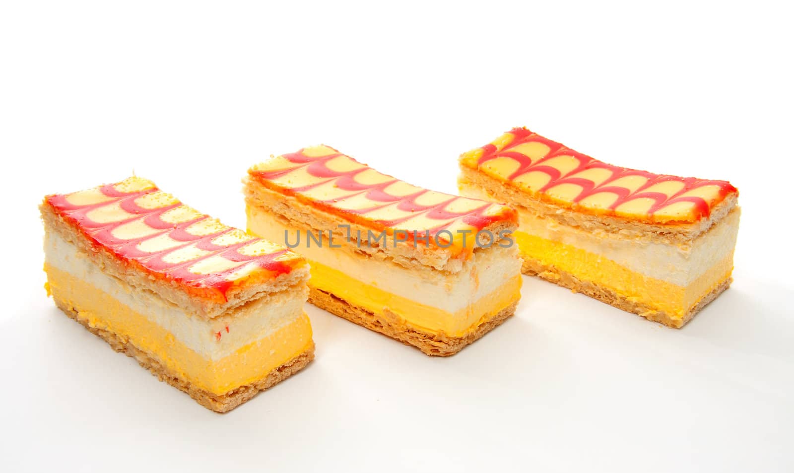 three delicious yellow Tompouce pastry isolated over white background