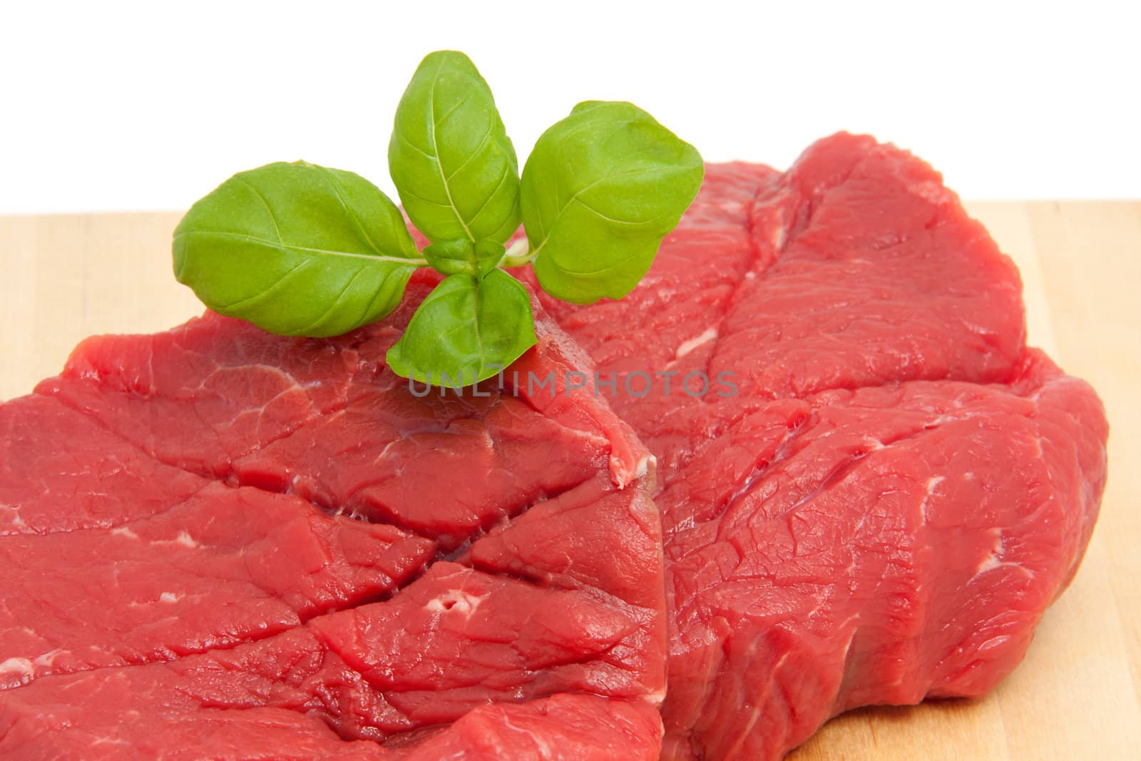 raw steak meat on cutting board in closeup over white background