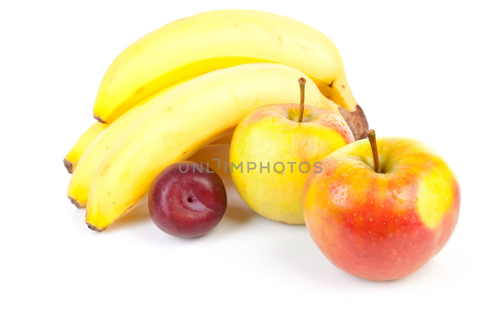 fresh fruits: bananas, apples and plum over white background