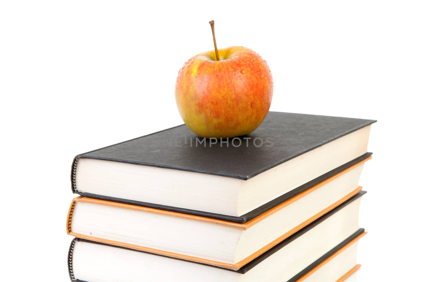 back to school: stack of books with apple on top over white background