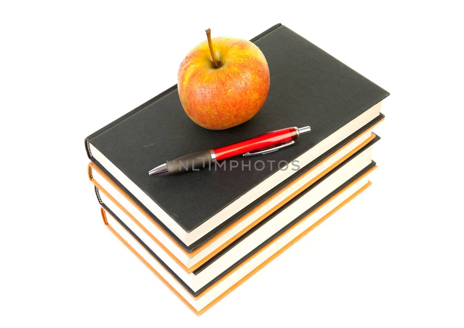 back to school: stack of books with apple and pen on top over white background