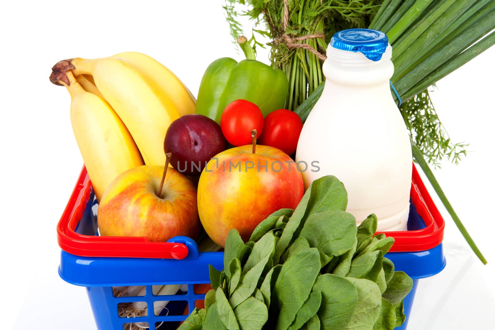 Shopping basket in closeup filled with healthy grocery over white background