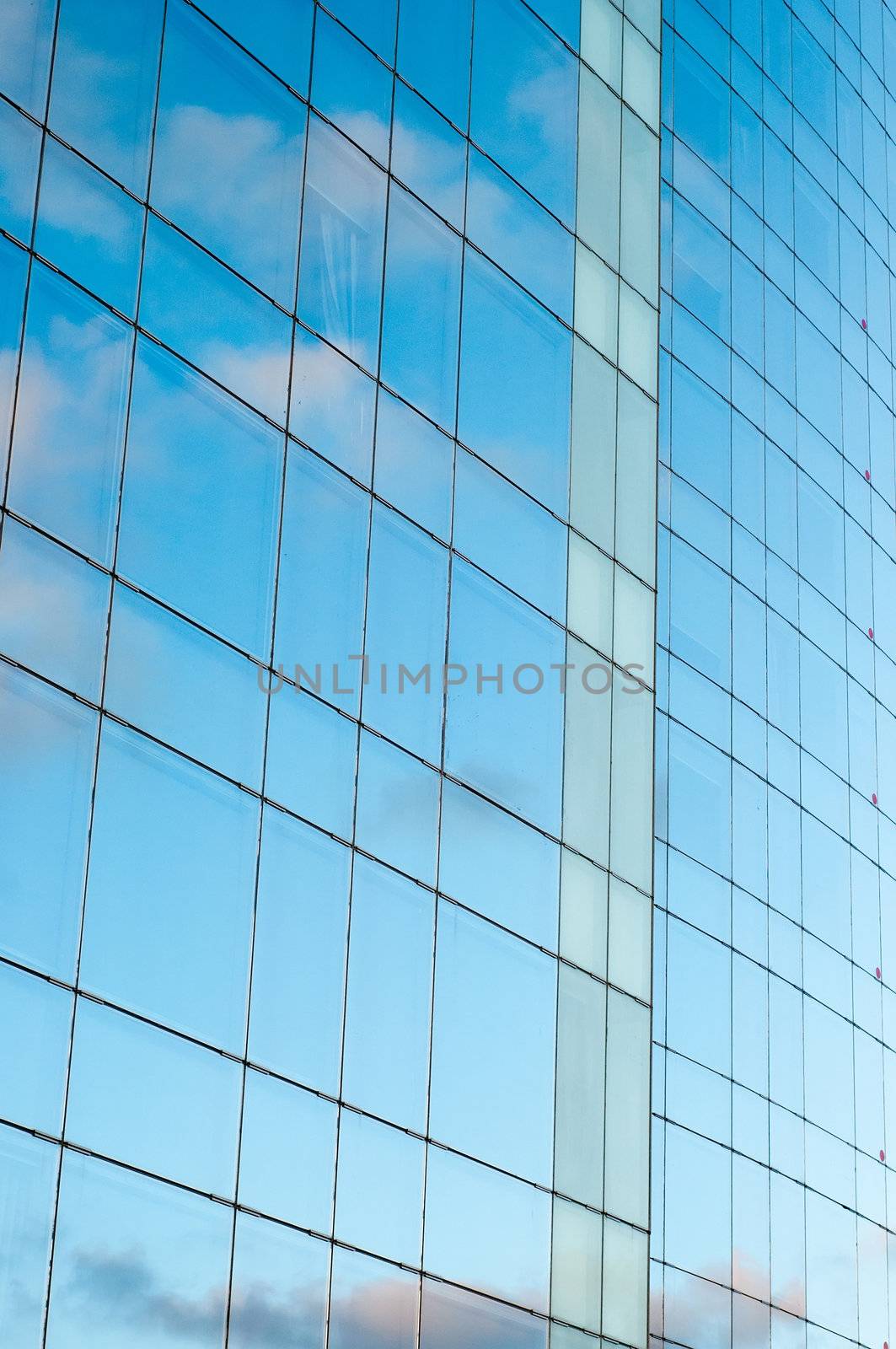 Office building and blue sky with clouds reflection