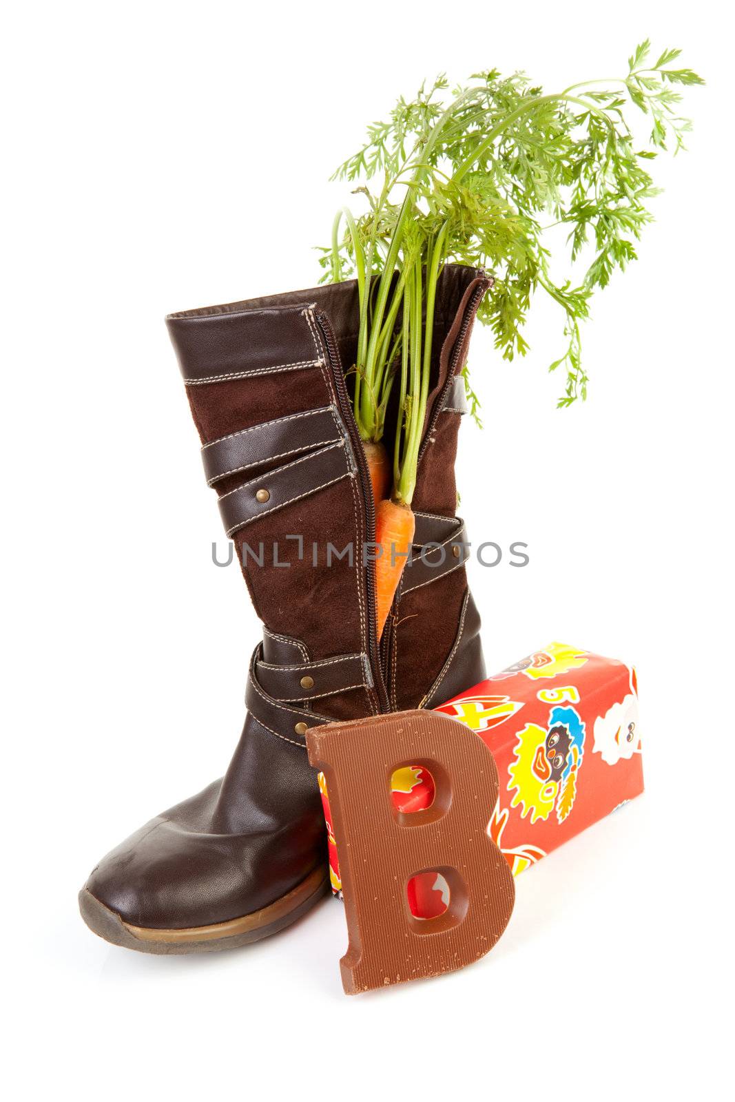 Shoe with carrot, chocolate letter and present over white background, typical Dutch tradition for Sinterklaas in december