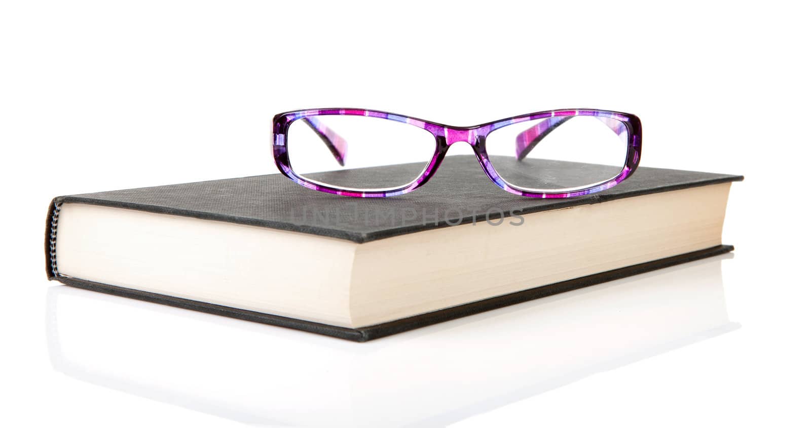 black book with purple reading glasses isolated on white background