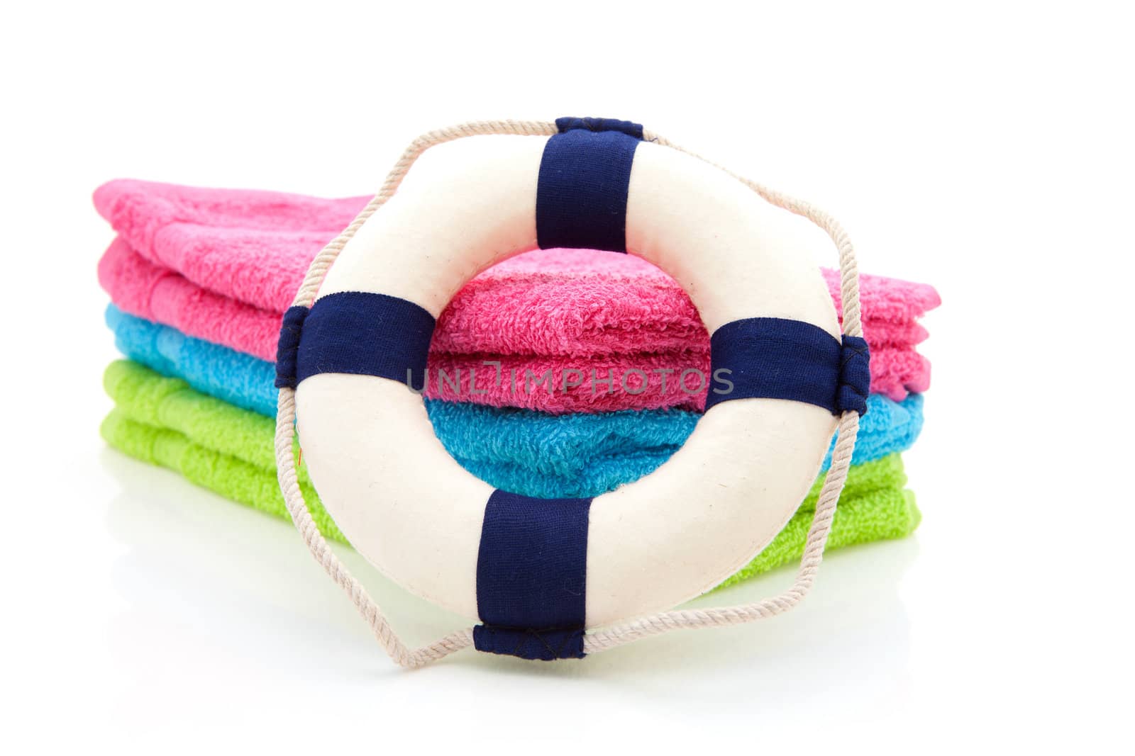 colorful towels and life buoy over white background