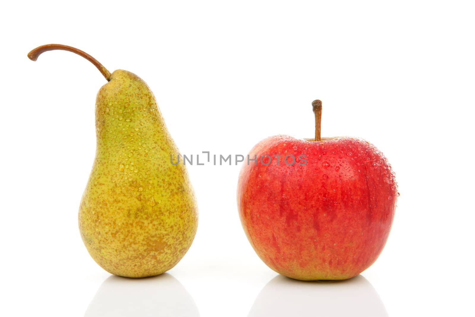Juicy pear and red apple with water drops over white background