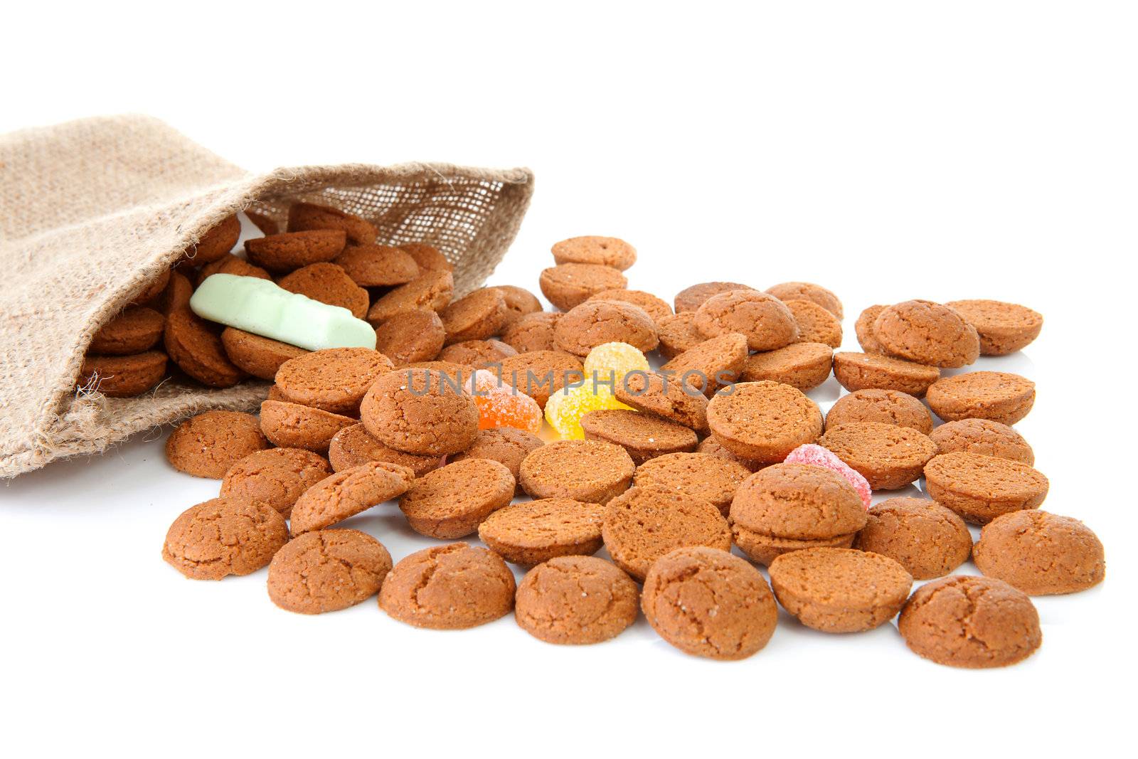 bag with typical dutch sweets: pepernoten (ginger nuts) for a celebration at 5 december in the Netherlands over white background