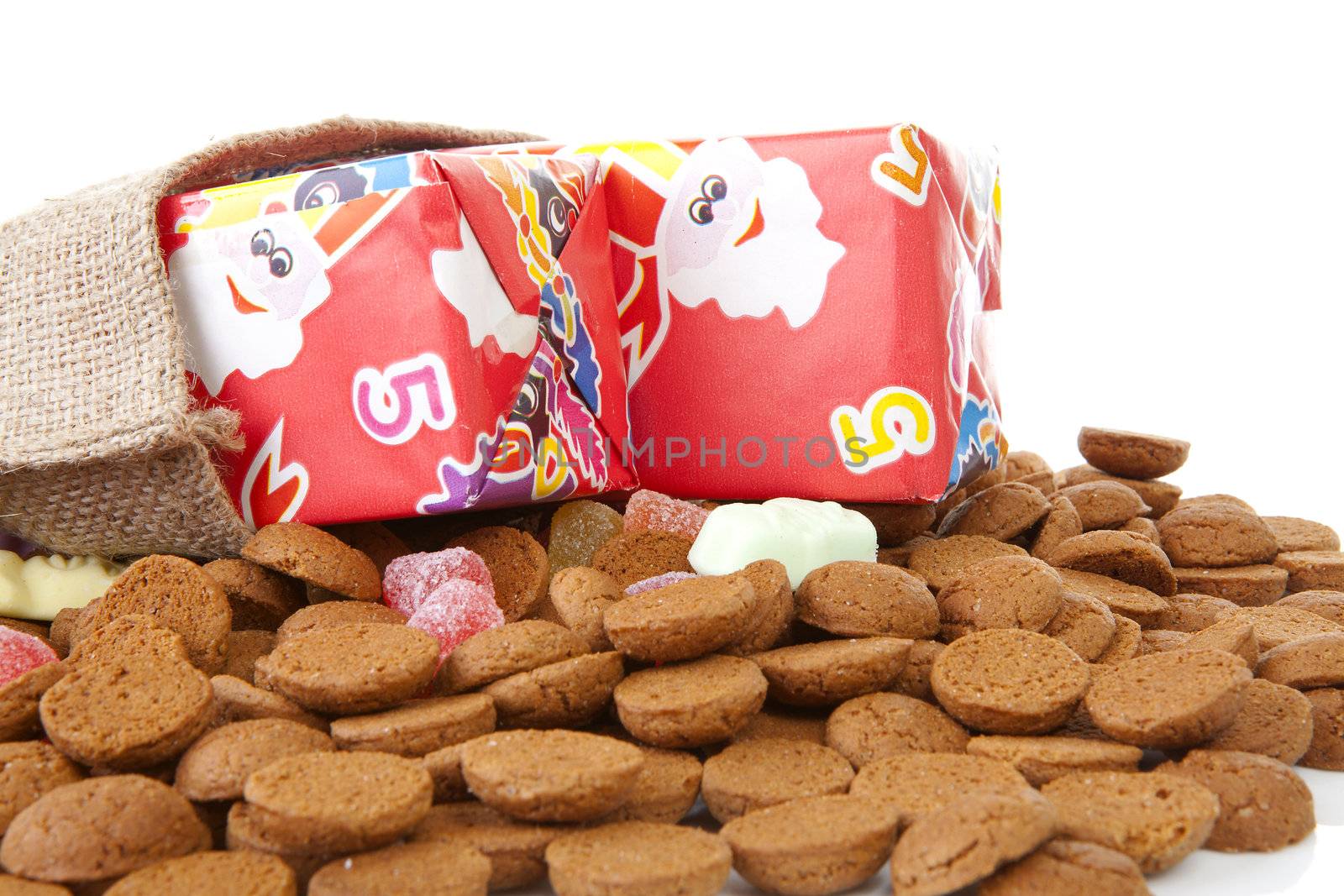 bag with presents and typical dutch sweets: pepernoten (ginger nuts) for a celebration at 5 december in the Netherlands over white background 
