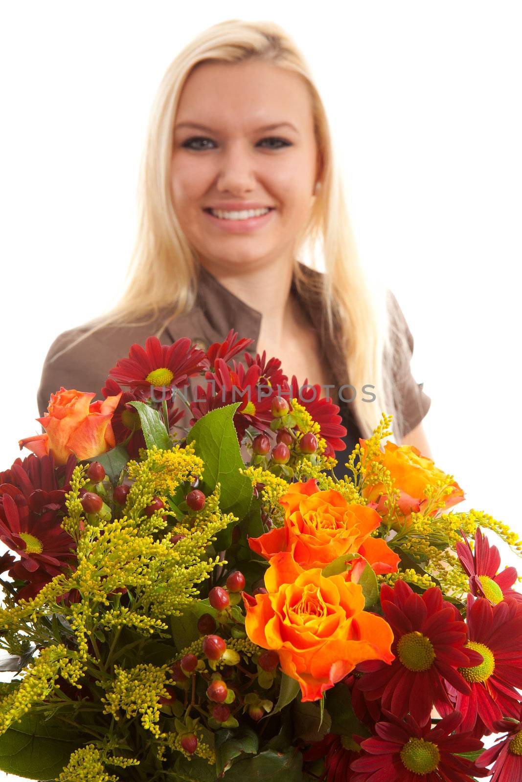 Young blonde woman gives beautiful bouquet with focus on flowers and woman in blur over white background