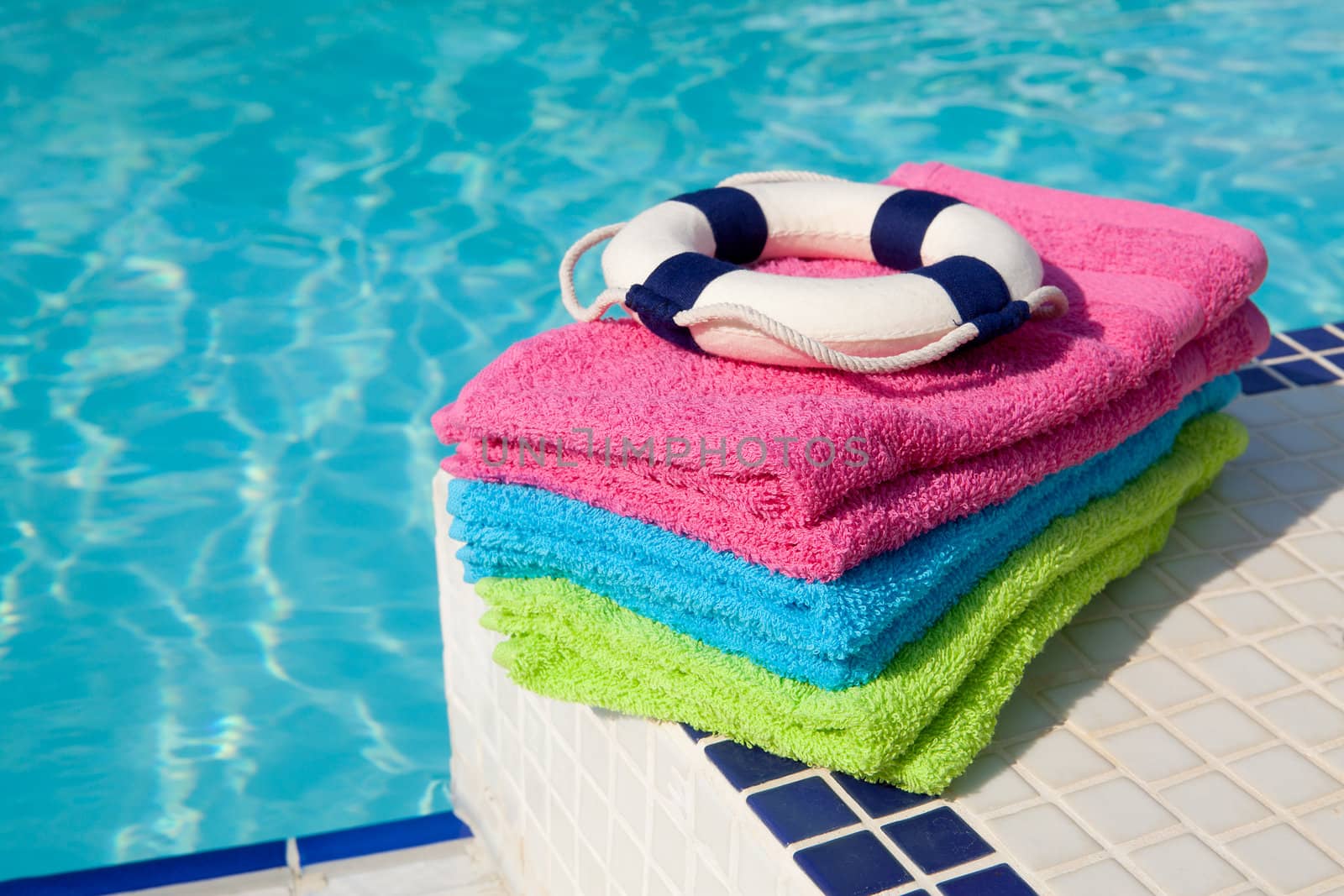 colorful towels and life buoy near the swim pool