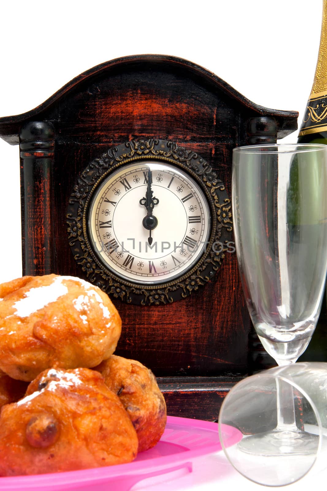 Dutch donut also known as oliebollen, traditional New Year's eve food and clock on midnight isolated on white background