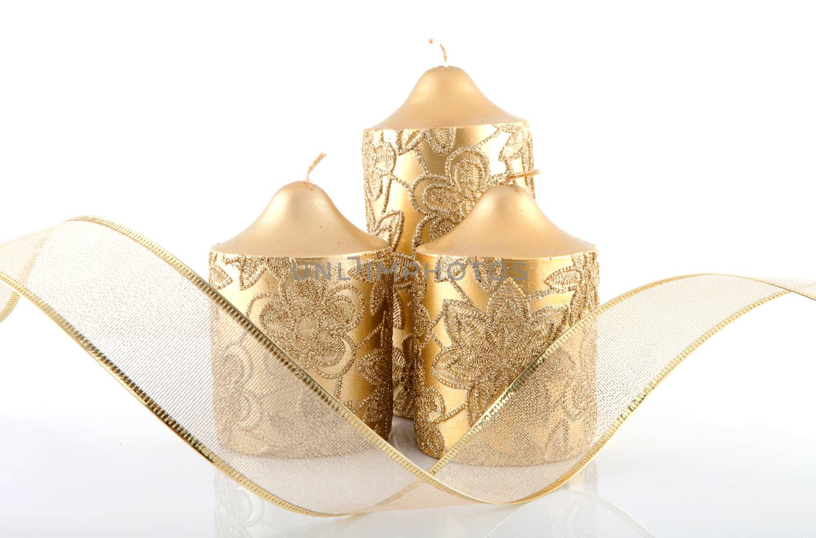 three golden candles and bow isolated on white background