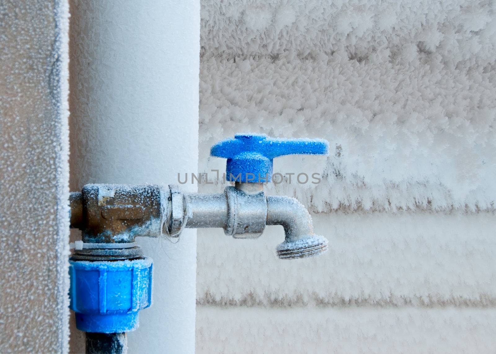 Frozen faucet in winter. Outdoor faucet frosted