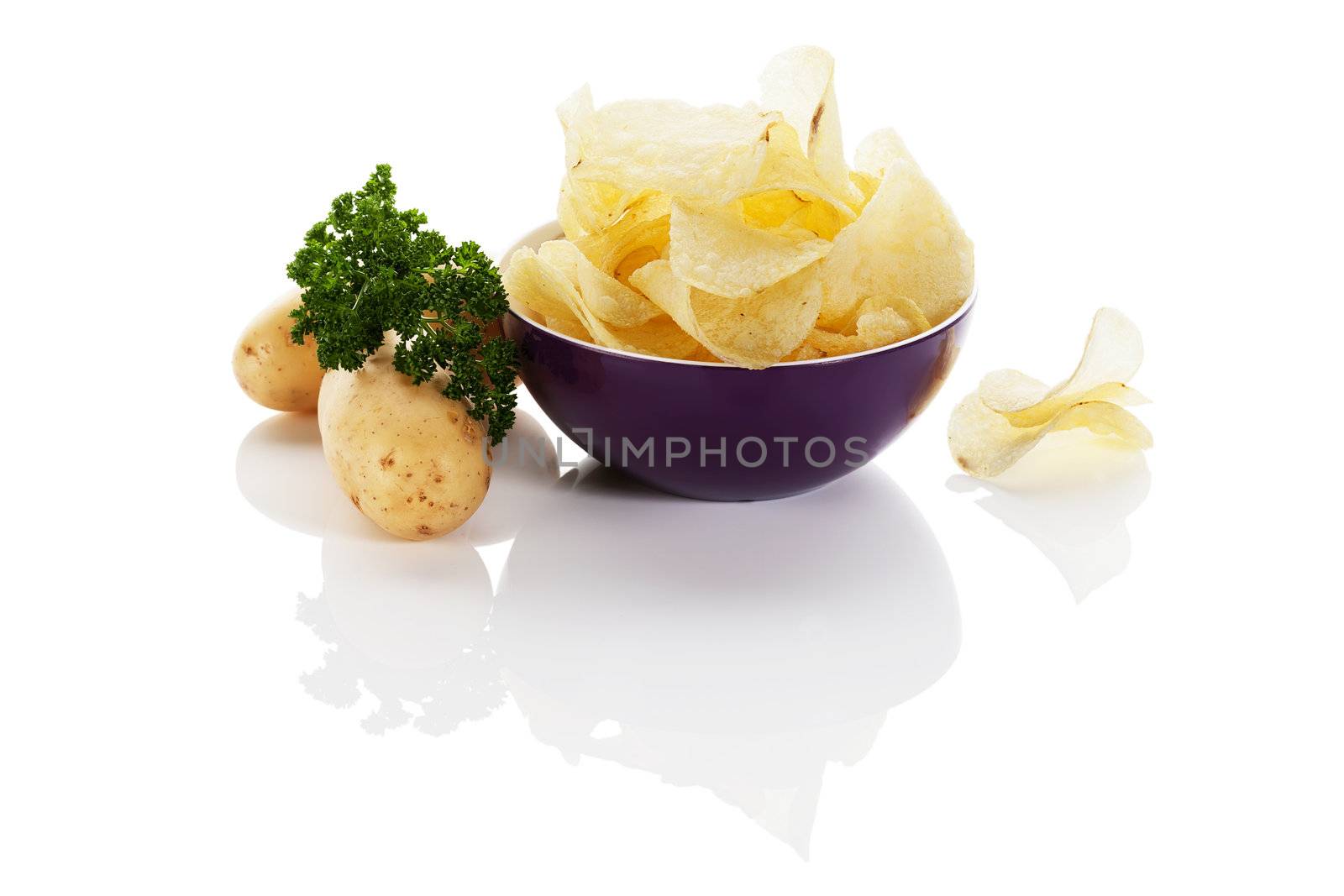 potato chips in a purple small bowl with potatoes aside on white background
