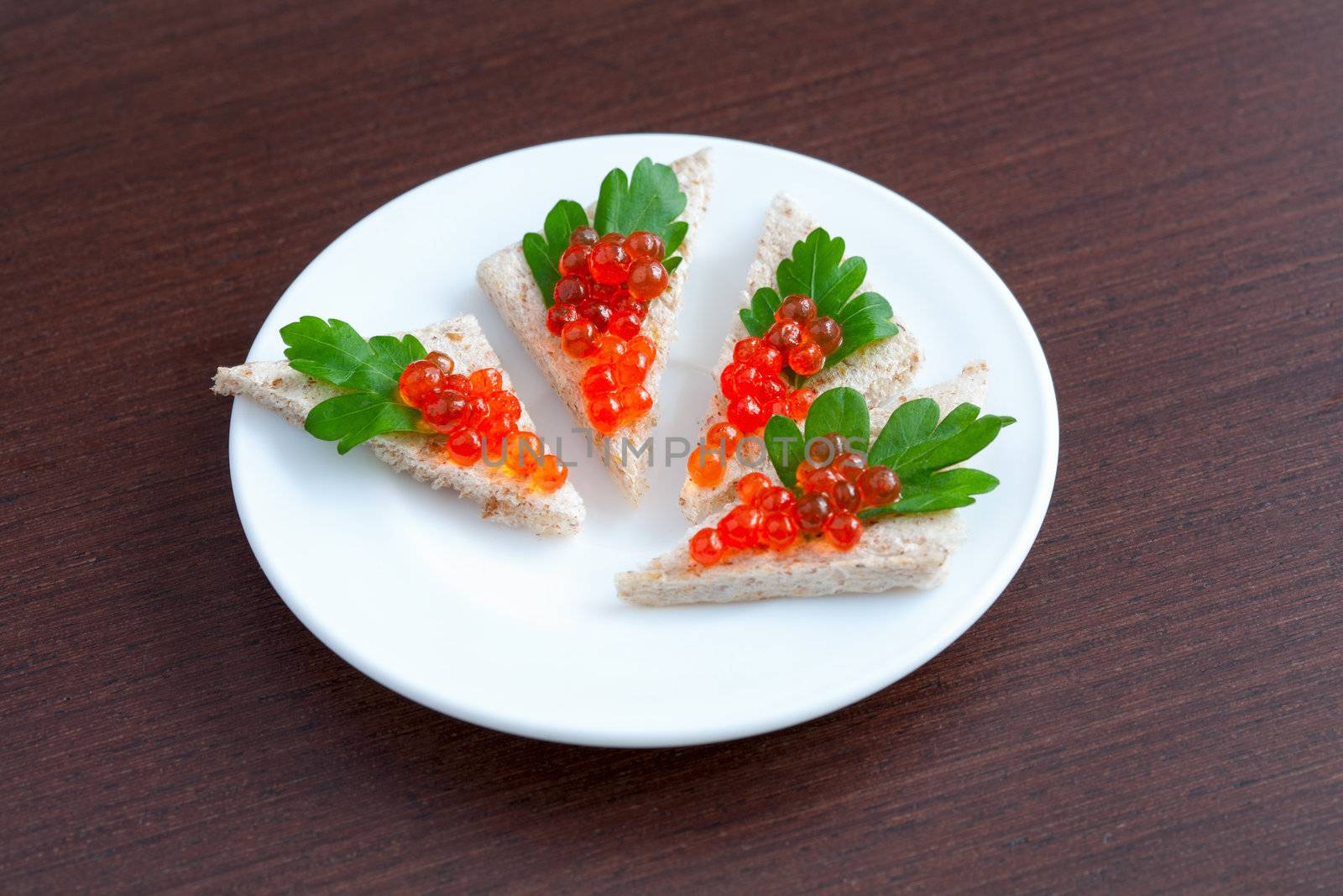 Tartlets with caviar and parsley on a plate