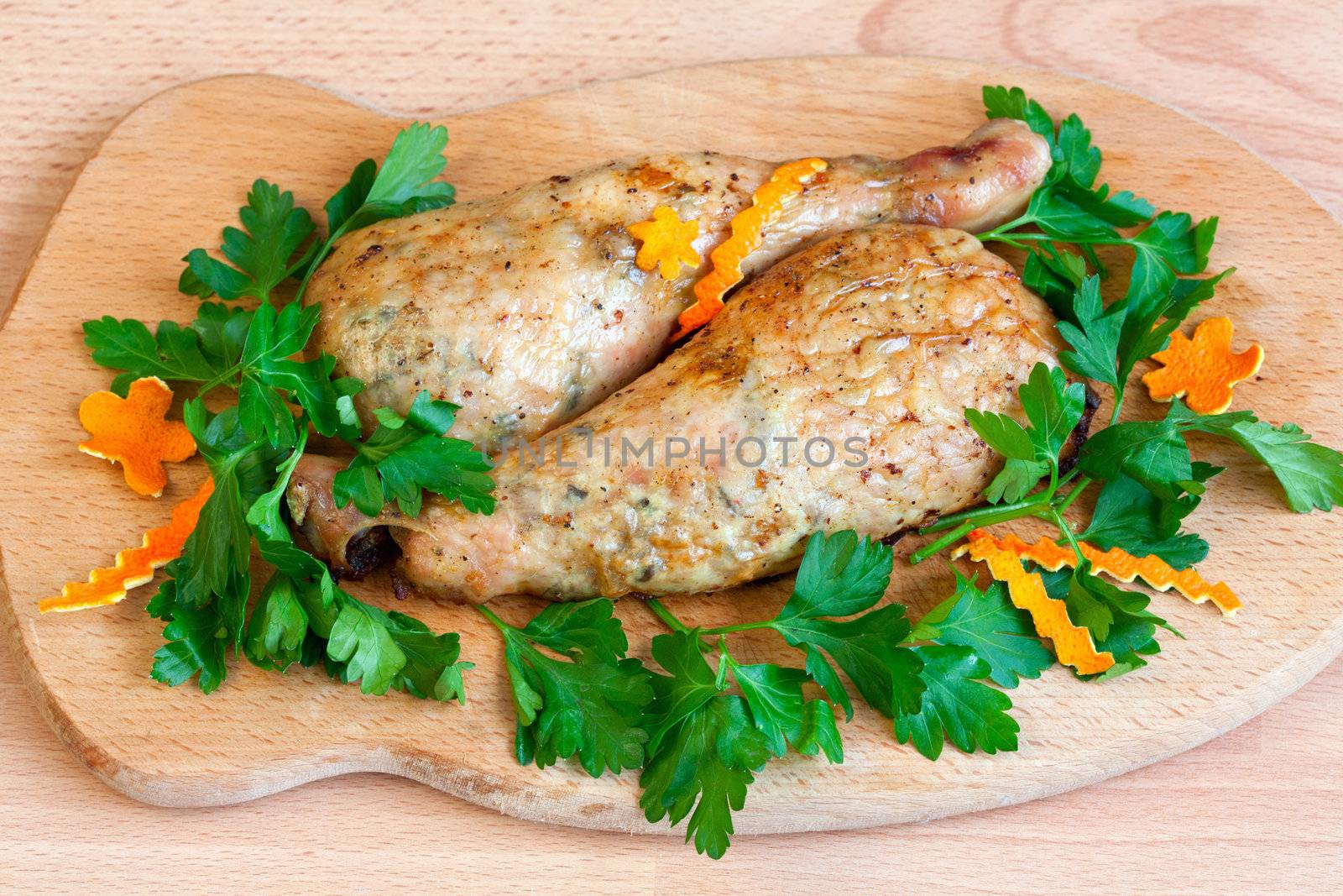 Fried chicken legs with parsley on the board by sfinks