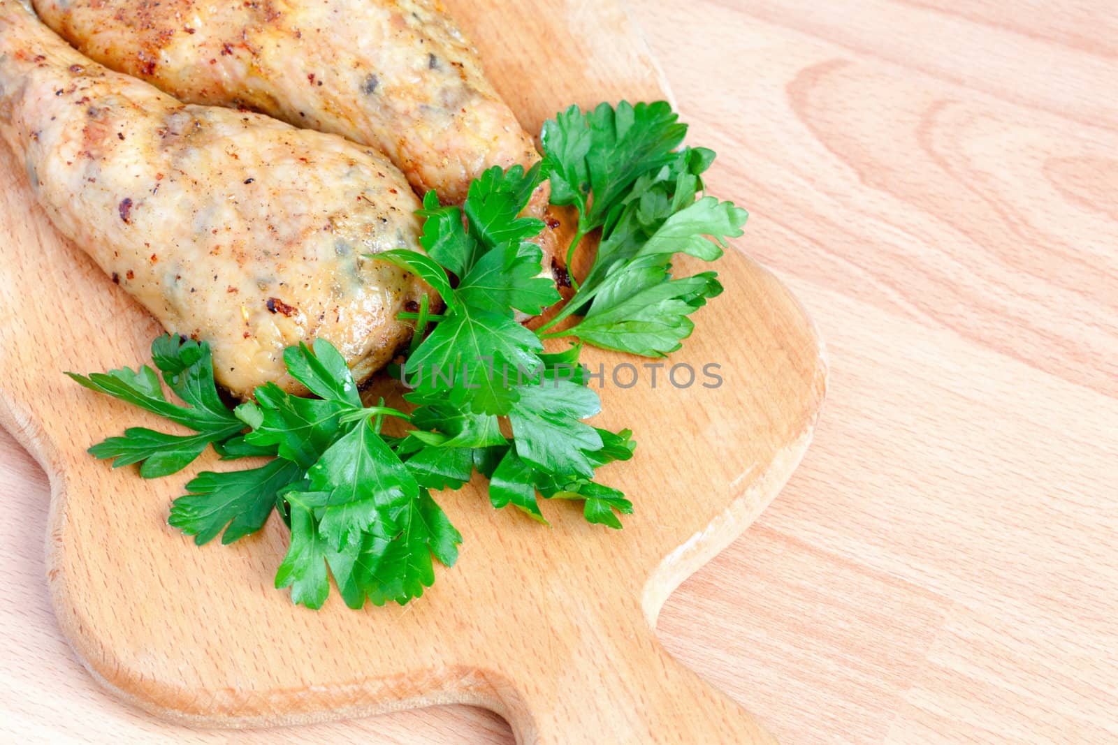 Fried chicken legs with parsley on the board by sfinks