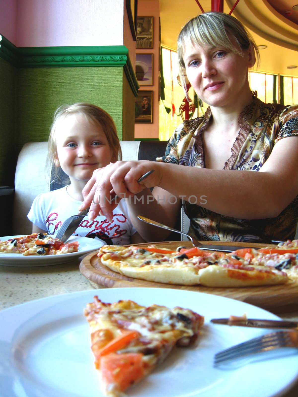Happy and smiling mother and her child in pizzeria