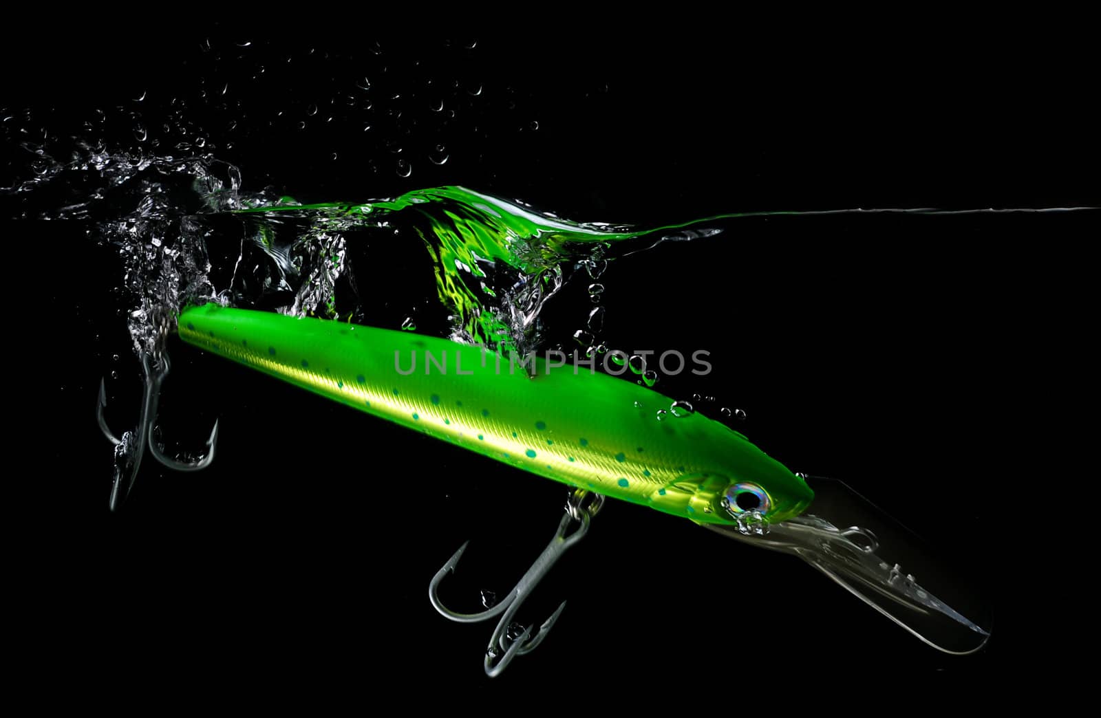 Green lure making a splash in water on black background