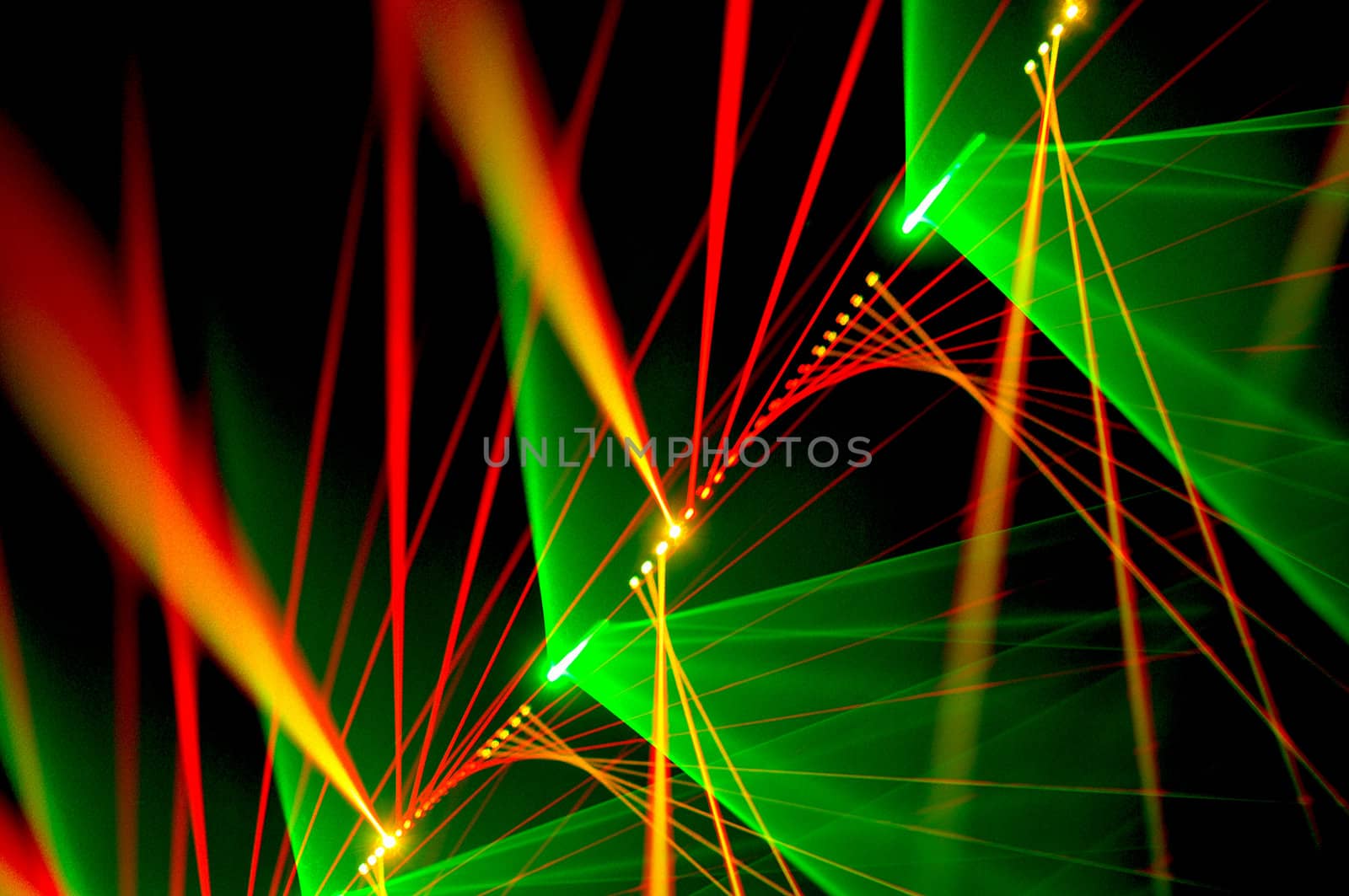 Colour lasers in smoke on a black background.