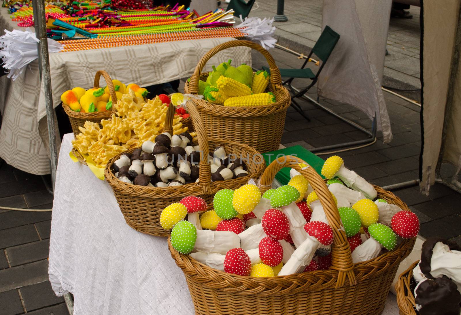 colorful mushroom corn pear shape candy sweet in wicker basket sold in outdoor street market fair.