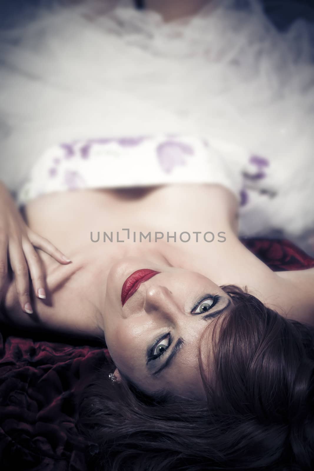 Red Hair. Fashion Girl Portrait. Attractive sexy woman lying on the bed in her room