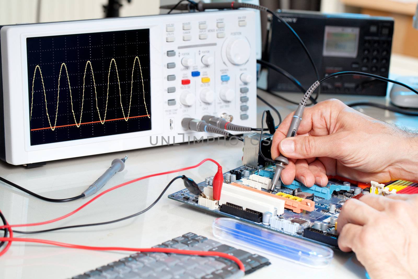 Tech tests electronic equipment in service centre