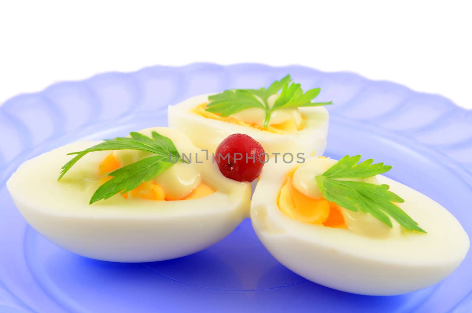 Cooked boiled eggs with sauce, decorated with parsley and cranberry