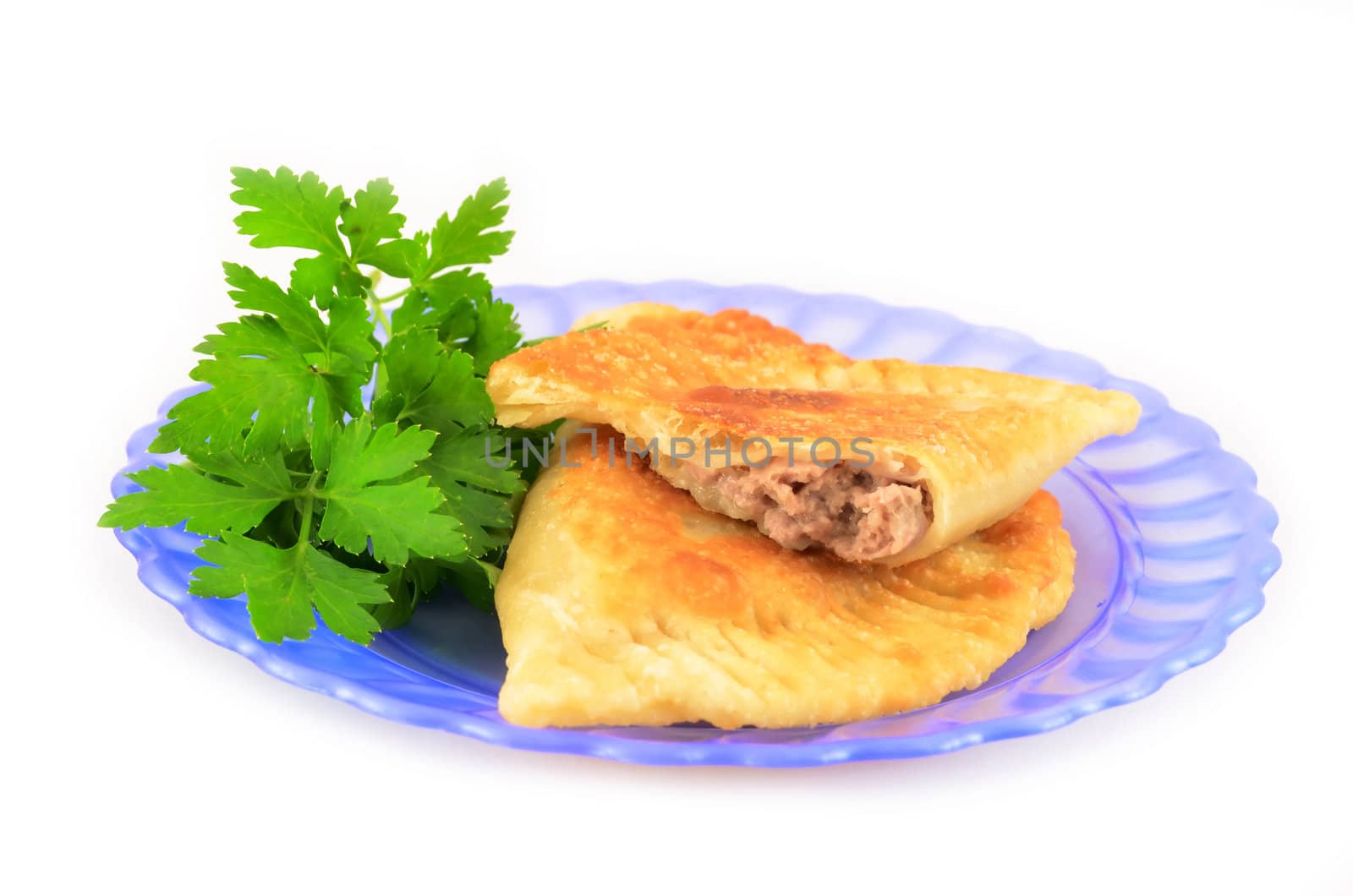 Pasties with meat on a plate decorated with parsley