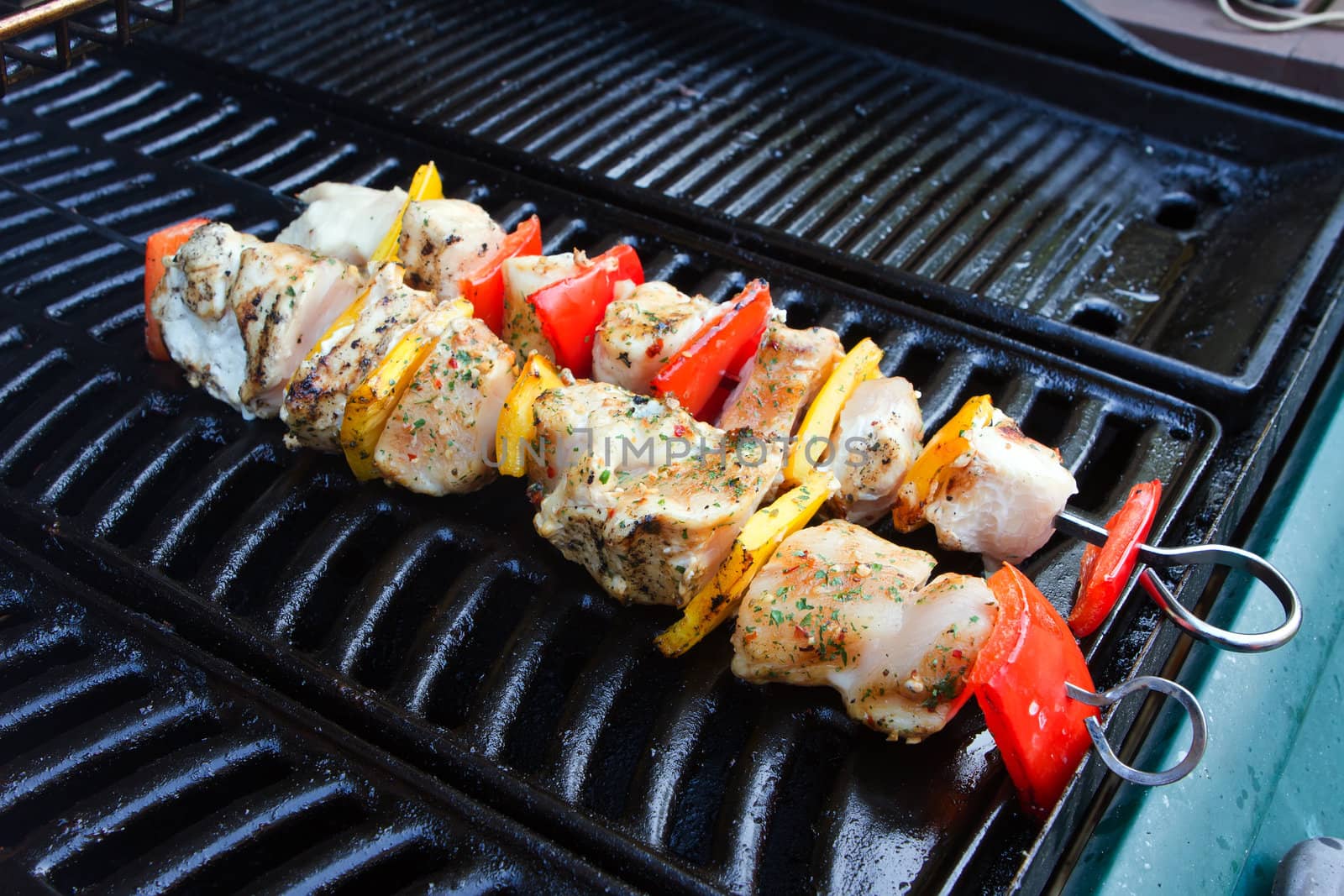 chicken and pepper kebabs slowly cooking on the barbecue