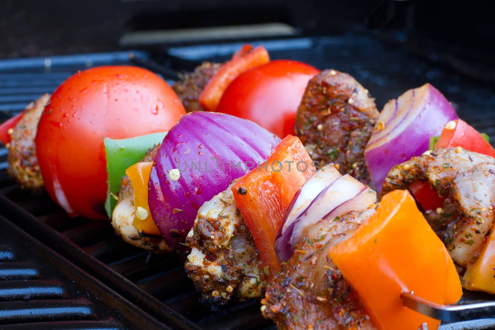 chicken and pepper kebabs slowly cooking on the barbecue by smikeymikey1