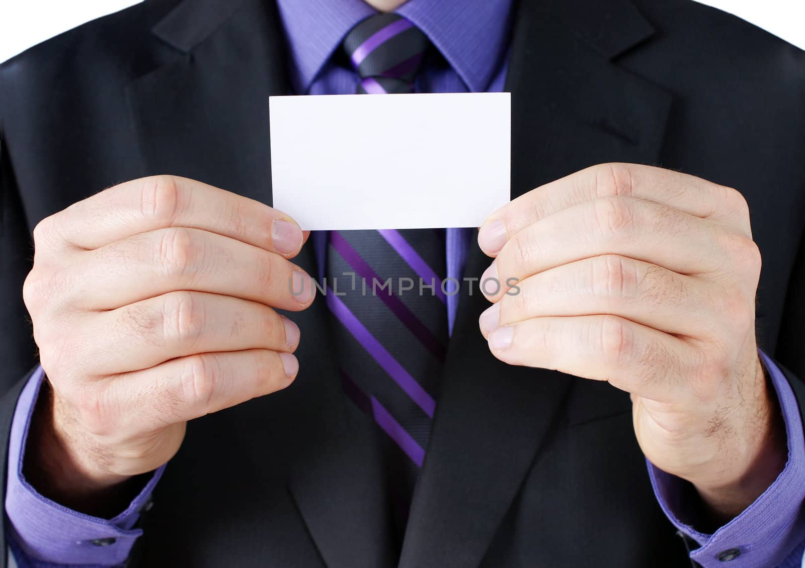 Business concept: caucasian hands of a businessman in dark suit with purple shirt and striped tie, holding a blank card, ready for your text.